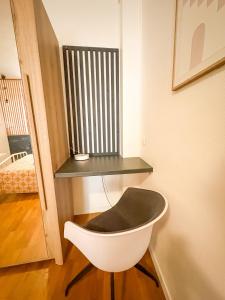 a white chair sitting in a room with a shelf at À deux pas du métro in Paris