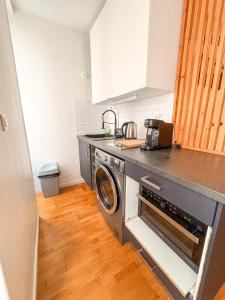 a kitchen with a washer and a washing machine at À deux pas du métro in Paris