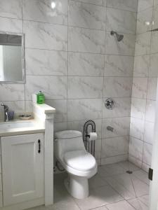a white bathroom with a toilet and a sink at chill spot on the green in Belmont