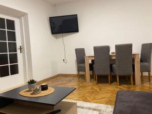 a living room with a table and chairs and a television at Venus 1 in Kula