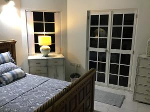 a bedroom with a bed and a lamp on a dresser at chill spot on the green in Belmont