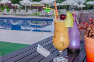 a drink sitting on a table next to a pool at Palmyra Beachfront Studios in Nydri