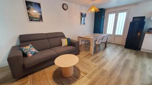 a living room with a couch and a table at Pépite citadine à St Pierre in Saint-Pierre