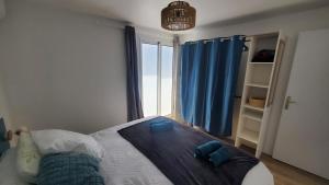 a bedroom with a bed with a large window at Pépite citadine à St Pierre in Saint-Pierre