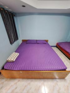 a bed in a room with a purple mattress at บ้านสายรุ้ง กระทุ่มแบน in Samut Sakhon