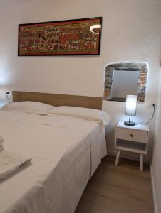 a bedroom with two beds and a mirror and a lamp at Santo 41 in Vernazza