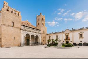 an old building with a tower and a church at Monreale Prestige Rooms B&B in Monreale