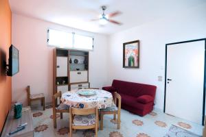 a living room with a table and a red couch at Argo apartment, fronte mare, kaucana beach in Villaggio Azzurro