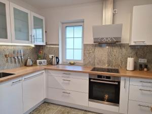 a kitchen with white cabinets and a stove top oven at Modern & Gemütlich XL in Linden +14 photos