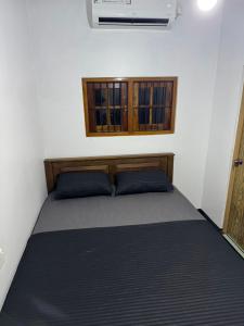 a bed with blue pillows in a room with a window at Dilco Villa Ahangama in Ahangama