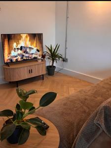a living room with a flat screen tv on a stand at Rosscarbery in Temple Bridge