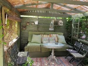 an outdoor patio with a table and a pergola at Cute gardenhouse close to Stockholm City in Solna