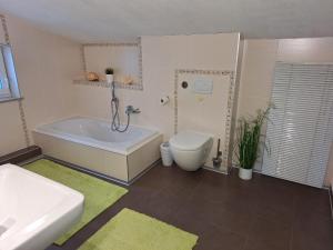 a bathroom with a tub and a toilet and a sink at modern und gemütlich in Linden