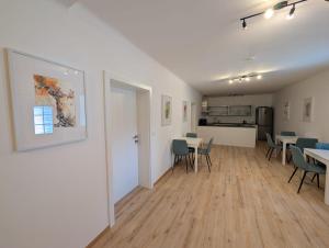 a room with tables and chairs and a kitchen at Wagramzimmer - Satzingerhof in Großwiesendorf