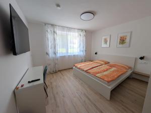 a bedroom with a bed and a desk and a window at Wagramzimmer - Satzingerhof in Großwiesendorf
