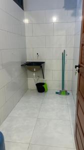 a white tiled bathroom with a sink and a floor at Residencial Ebenezer conforto perto da ufac in Rio Branco