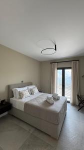 a bedroom with a large bed with two towels on it at Villa Loggia in Ferendináta +27 photos