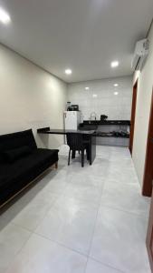 a living room with a black couch and a table at Residencial Ebenezer conforto perto da ufac in Rio Branco