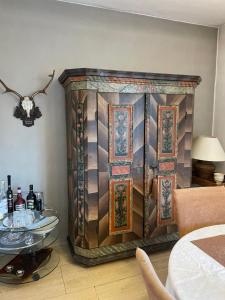 a large wooden cabinet in a room with a table at Haus Doris in Perchtoldsdorf +12 photos