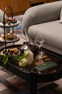 a coffee table with food and wine glasses on it at Grand Dior in Tashkent