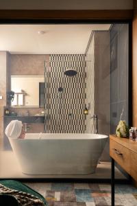 a bathroom with a white tub and a shower at Grand Dior in Tashkent