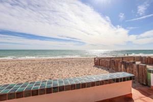 a view of a beach with a bench and the ocean at Aventura in Puerto Peñasco