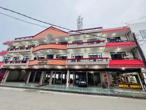 a large building with red roofs on a street at Hotel Amrit in Bharwain