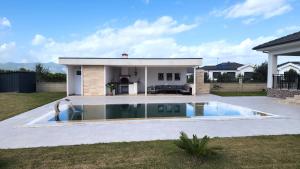 a swimming pool in front of a house at Villa Melara in Kızılyurd