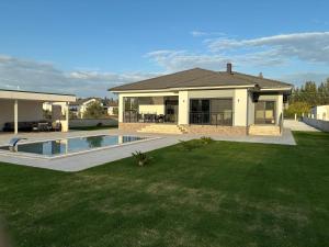 a house with a swimming pool in a yard at Villa Melara in Kızılyurd