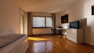 a bedroom with a bed and a desk with a television at ask rooms Privatzimmer in Kassel in Kassel