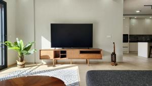 a living room with a flat screen tv on a wooden entertainment center at Villa Melara in Kızılyurd