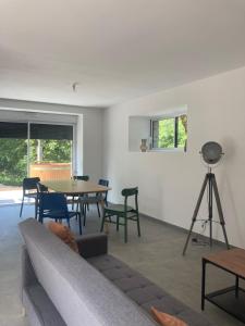 a living room with a couch and a table and chairs at Gîte Les Douets in Isigny-le-Buat
