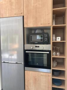 a microwave and a refrigerator in a kitchen at Gîte Les Douets in Isigny-le-Buat +7 photos