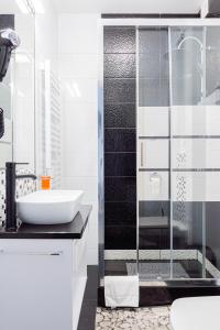 a bathroom with a sink and a glass shower at Kamienica Pod Neptunem - Rynek Puck - Śniadanie w cenie - 200m do Molo in Puck