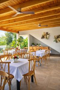 a dining room with white tables and wooden ceilings at Ocean Winds Hotel in San Felipe de Puerto Plata