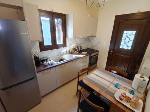 a kitchen with a table and a sink and a refrigerator at Metsovo Fireplace Retreat I in Metsovo