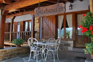 a table and chairs on the porch of a building at Apart con piscina Lebanes Picos de Europa in Torices