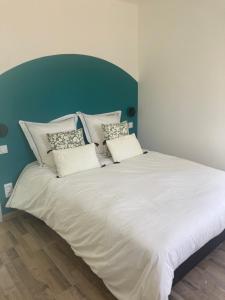 a large bed with white sheets and pillows on it at Gîte Les Douets in Isigny-le-Buat
