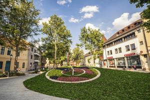 a circular garden in the middle of a city street at Tamás Apartman - Panorámás, tágas lakás a történelmi belvárosban kilátással a Virágórára in Székesfehérvár