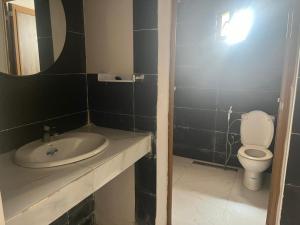 a bathroom with a sink and a toilet and a mirror at Duplex sahrawi in Nouakchott +13 photos