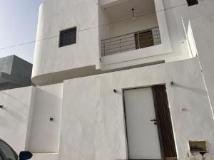 a white building with a door on the side of it at Duplex sahrawi in Nouakchott