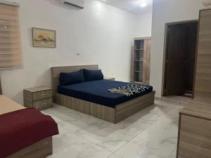 a bedroom with a bed with blue sheets on it at Duplex sahrawi in Nouakchott