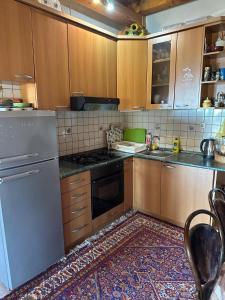 a kitchen with wooden cabinets and a white refrigerator at Kuća za odmor VITICA s vanjskim kaminom in Kupres
