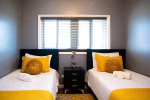 a bedroom with two beds with yellow pillows and a window at Vacation Haven in Rolleville