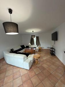 a living room with a white couch and a table at Maison de village in Mecquignies