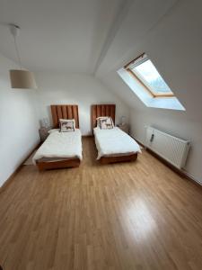 two beds in a room with a skylight at Maison de village in Mecquignies