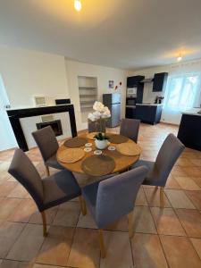 a dining table and chairs in a living room at Maison de village in Mecquignies