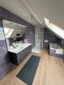a bathroom with a sink and a tub and a mirror at Maison de village in Mecquignies +12 photos