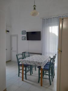 a dining room with a table and chairs and a television at Poseidone Ponza in Ponza +7 photos