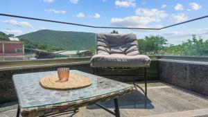 a patio with a table and a chair on a balcony at Luxury Living Peramos in Nea Peramos